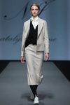 Pokaz Natālija Jansone — Riga Fashion Week SS2022 (ubrania i obraz: bluzka biała, garnitur damski (żakiet, spódnica) szary, rajstopy czarne, buty sportowe białe)