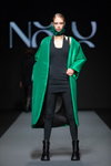 Pokaz NÓLÓ — Riga Fashion Week SS2022 (ubrania i obraz: palto zielone, botki czarne, rajstopy czarne, sukienka mini czarna)