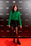 Goście — Riga Fashion Week SS23 (ubrania i obraz: pulower zielony, spódnica mini czarna, rajstopy czarne)
