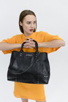 Kampania Clio Goldbrenner FW22 (ubrania i obraz: swetrowa sukienka pomarańczowa, torebka czarna)