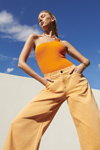 Kampania River Island SS 2022 (ubrania i obraz: top pomarańczowy, jeansy beżowe)