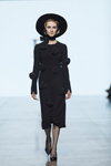 Pokaz IVETA VECMANE — Riga Fashion Week AW23/24 (ubrania i obraz: kapelusz czarny, suknia wieczorowa czarna, rajstopy czarne, półbuty czarne)