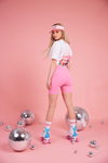 Camille Dhont. Kampagne von CAMILLE x JBC (Looks: rosane Radlershorts, weißes kurzes Top, weiße Socken)
