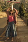 Kampagne von MOS MOSH SS 23 (Looks: Fuchsia Top, himmelblaue Jeans, goldene Sandaletten)