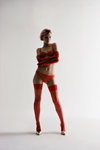 Kampania bielizny Chantelle X FW 23 (ubrania i obraz: pończochy czerwone, długie rękawiczki czerwone, biustonosz czerwony, figi czerwone, krótka fryzura, półbuty srebrne)